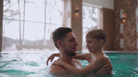family-wellness-center-for-children-and-adults-little-boy-and-his-father-are-swimming-together-in-pool